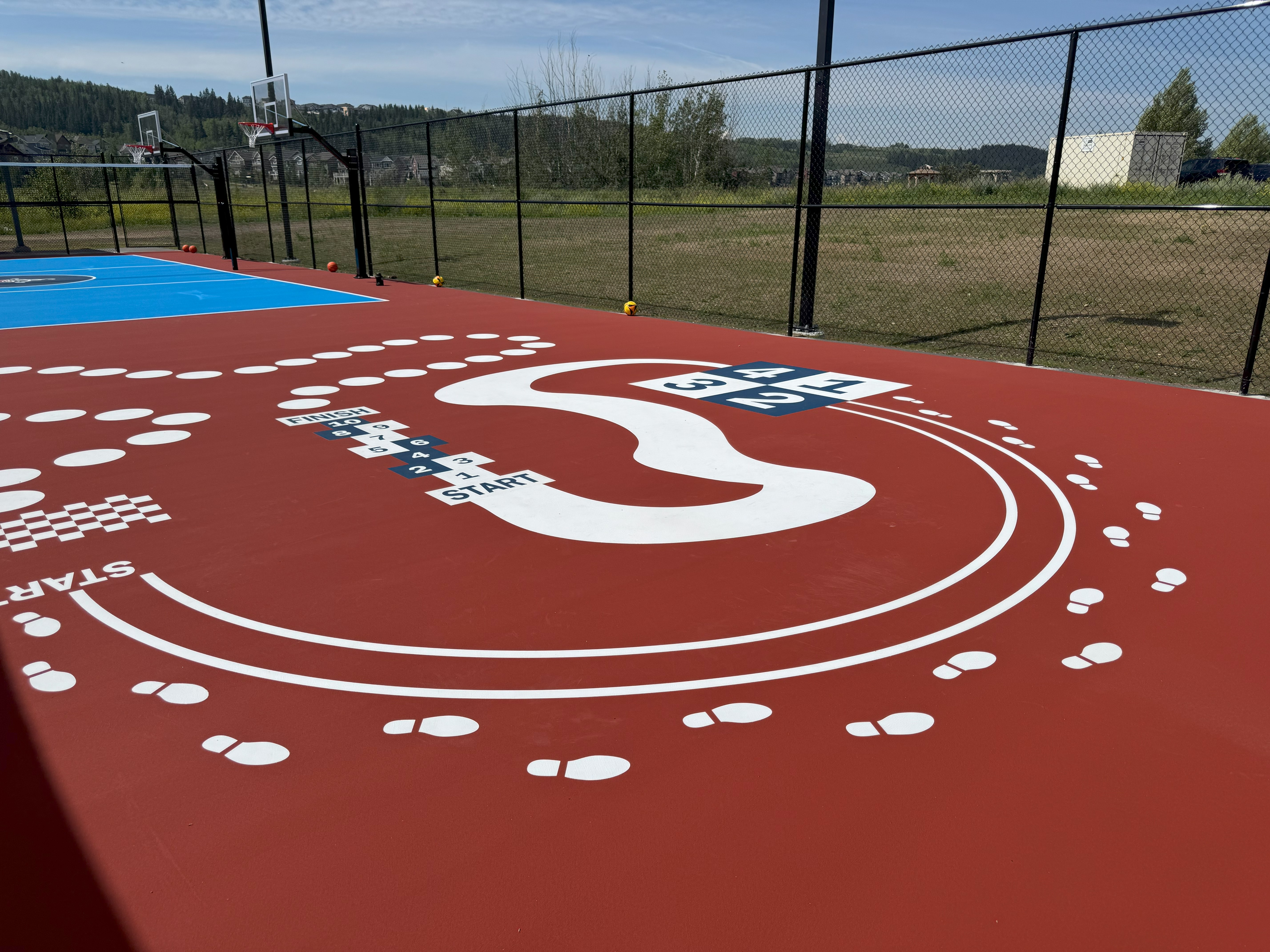 Red play surface with white markings for guided open play