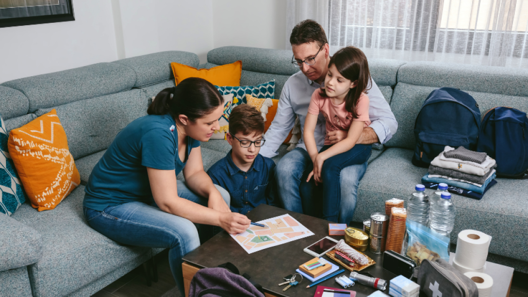 iamge of family making an emergency plan with emergency supplied around