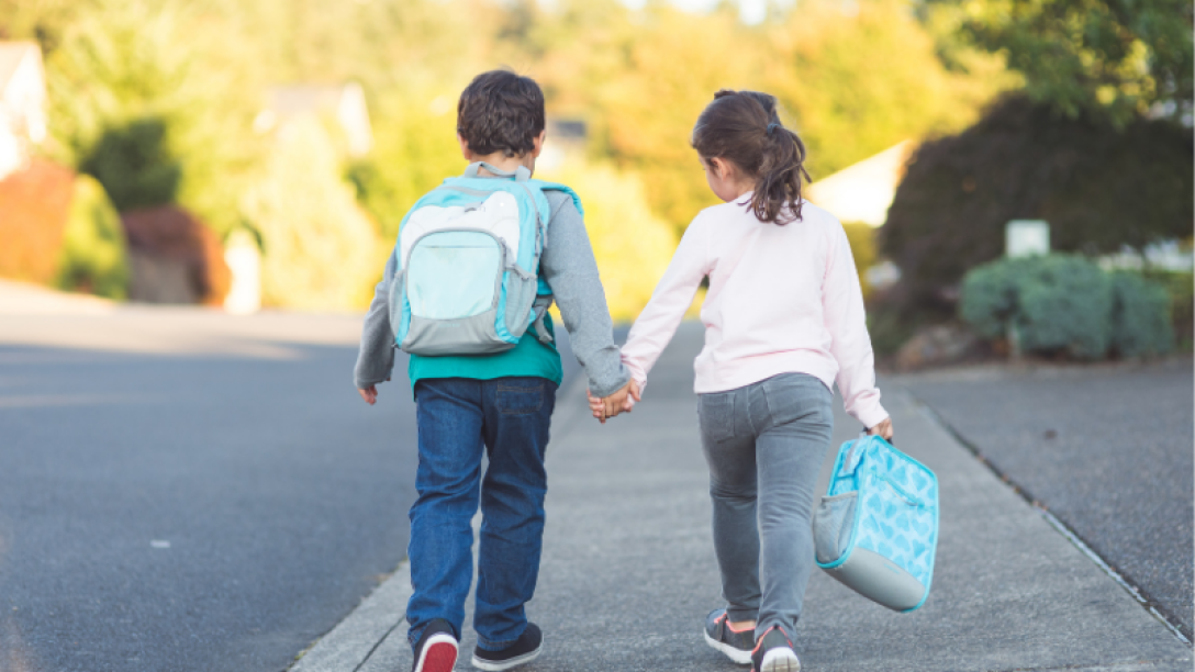Two kids walking to school